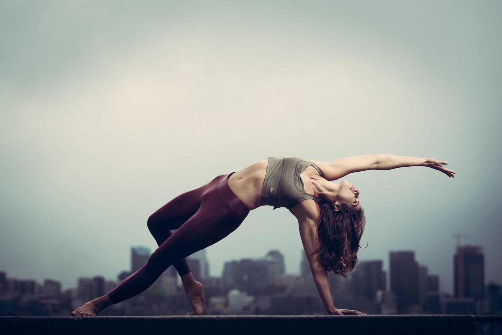 Celeste Caliri in a Pilates side-plank pose, Seattle skyline behind her