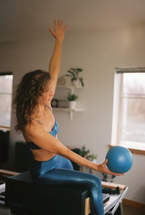 Celeste in a Pilates session with a small ball